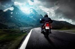 Plakat motocyklista góra słońce krajobraz jesień