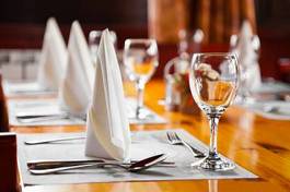 Obraz na płótnie kieliszki i talerze na stole w restauracji
