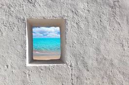 Fototapeta małe okienko w murze z widokiem na plażę
