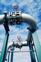 Fototapeta industrial zone, steel pipelines and valves against blue sky