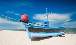 Plakat wooden fishing boat on the beach.
