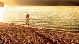 Plakat young woman jogging at the beautiful sun set