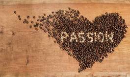 Plakat cuore di chicchi di caffè su un piano di legno grezzo.