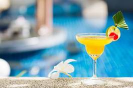 Obraz na płótnie yellow cocktail with lime by the pool