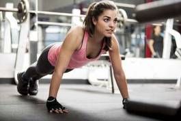Fotoroleta piękna kobieta ćwiczy na siłowni