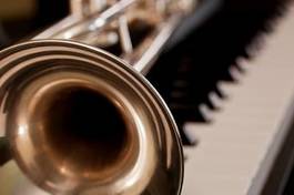 Plakat trumpet segment closeup lying on piano keys