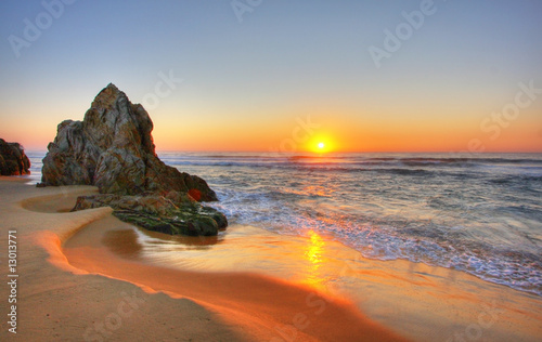 Obraz na płótnie Skały na plaży o zachodzie słońca