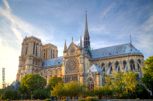 Naklejka Gorgeous sunset over Notre Dame cathedral with puffy clouds, Par