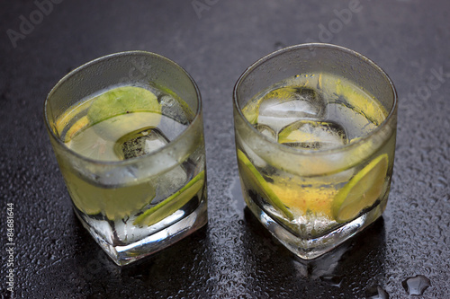 Fotoroleta Lemonade served on a dark marble bar with a lime