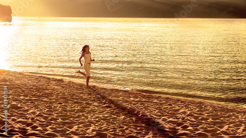 Fototapeta Young woman jogging at the beautiful sun set