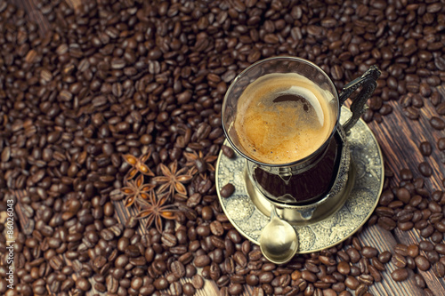 Fototapeta Coffee cup on coffee grains background