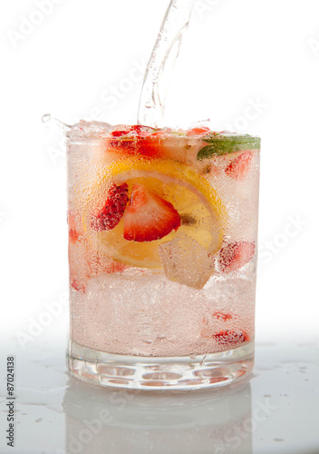 Fototapeta Seltzer Drink with Fresh cut fruit floating inside