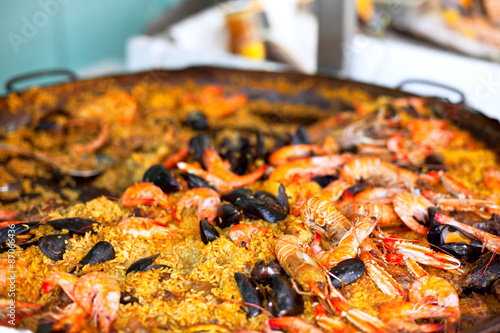 Naklejka Traditional paella with seafood in a market